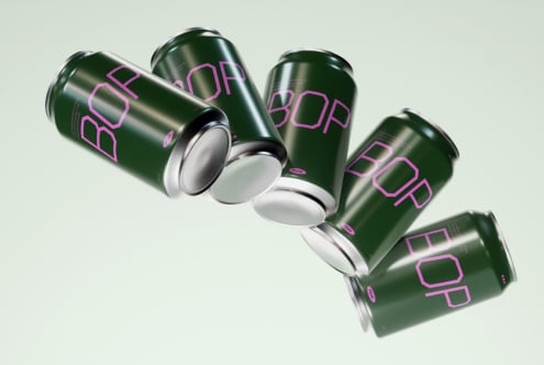 Floating green soda cans labeled BOP with magenta font on a light background perfect for beverage packaging mockups ideal for graphic designers.