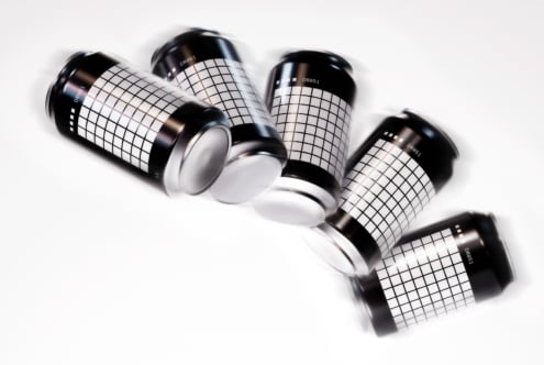 Mockup of five aluminum cans with grid design on a white background. Perfect for showcasing branding, packaging, and product design for designers.