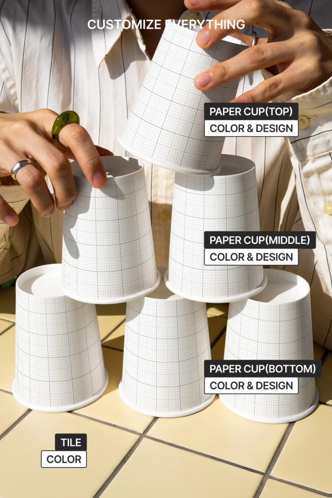 Paper cups with grid design stacked by person on tiled surface customizable for color and design perfect for graphic designers and product mockups.
