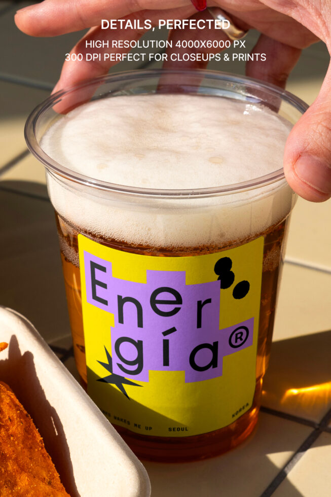 High-res photo of a plastic cup with frothy drink featuring bold graphic design with vibrant yellow and purple label; perfect for mockups and branding.