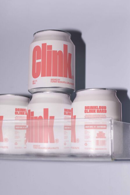 Stacked beer cans with coral Clink branding, reflective product shot on gray background