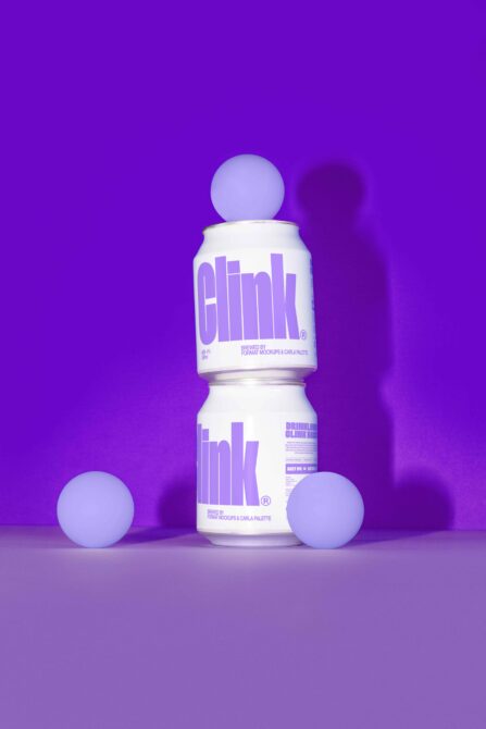 Colorful stacked beverage cans with purple sphere styling in vibrant scene