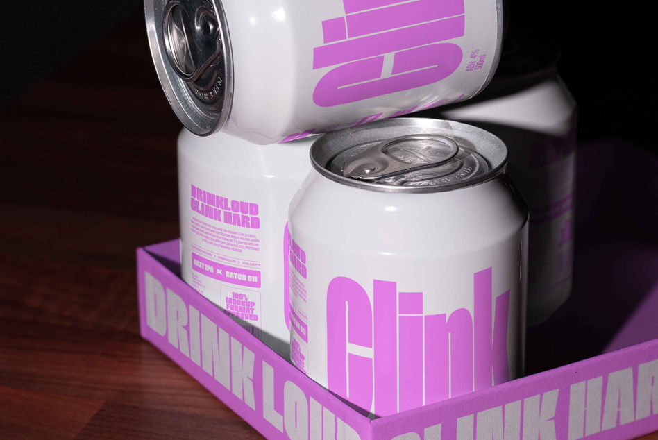 White beer cans with neon pink labels stacked in purple cardboard carrier