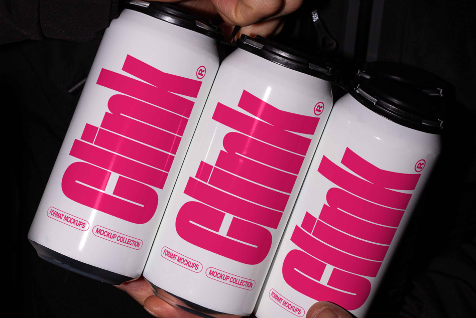 Three white cans with hot pink striped typography held up against dark background