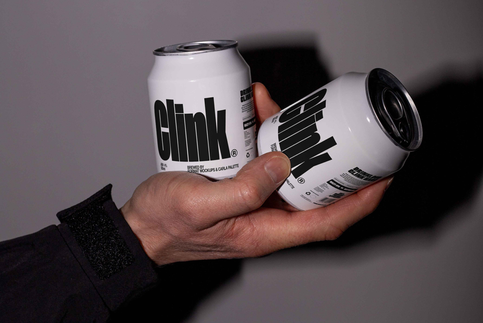Two white aluminum cans with bold black geometric logo held in hands