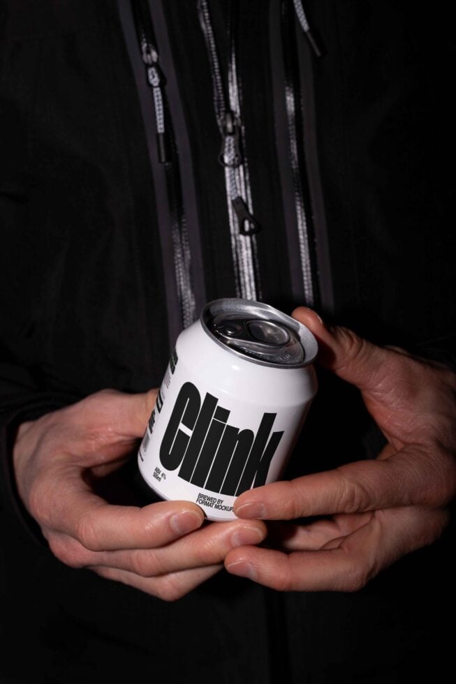 Man holding a can with bold text Clink suitable for beverage packaging mockup. Perfect for designers seeking realistic can mockups.