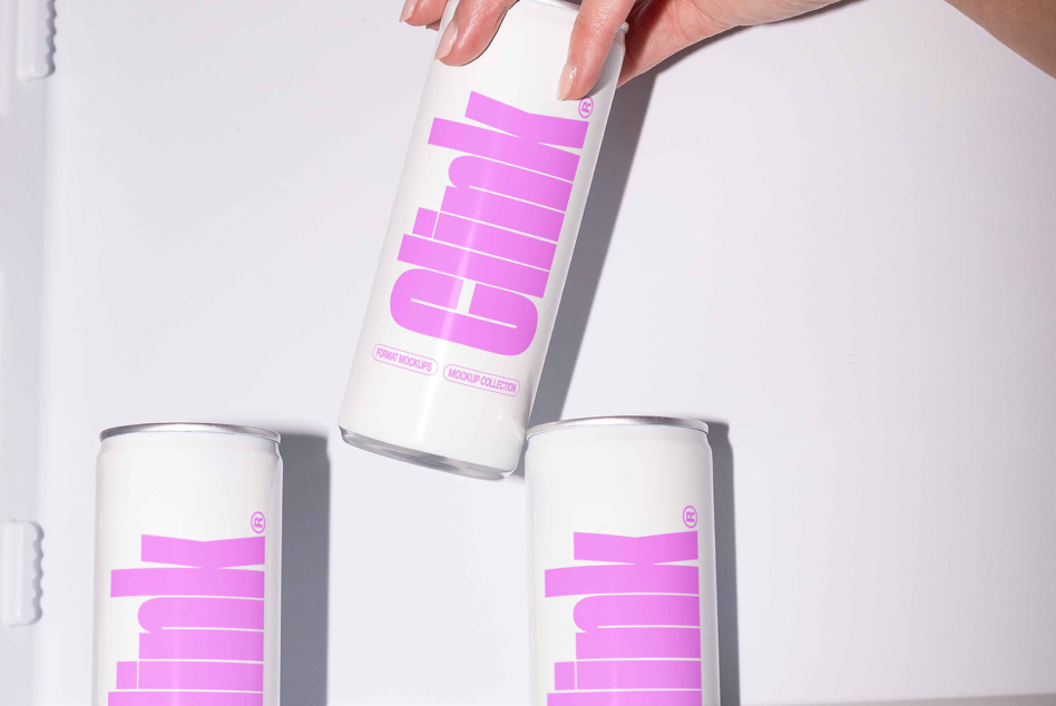 Hand holding white can with magenta geometric logo while two matching cans sit below