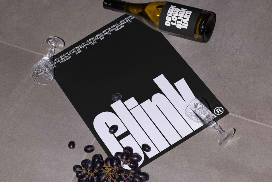White wine bottle label mockup beside black poster, styled flat lay with wine glasses