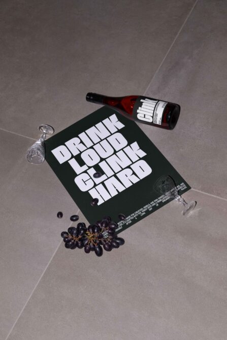 Dark wine bottle label mockup with black poster, overhead composition with scattered grapes