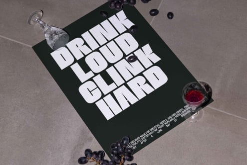 Typography poster design featuring bold white lettering on a dark background with scattered grapes and wine glasses. Perfect for templates and mockups.
