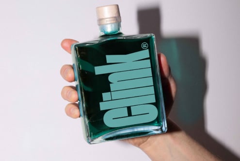 Hand holding a square glass bottle with teal liquid and bold branding. Perfect for mockup design, packaging, and graphic design projects.