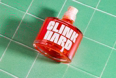Red bottle labeled Clink Hard on green tiled background. Perfect for graphic mockup projects bold fonts or packaging design digital assets for designers.