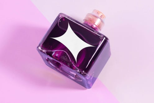 Purple glass bottle with logo on pink background suitable for mockup templates and graphic design projects. Perfect for branding and advertising designs.