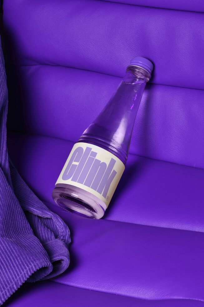 Purple-themed bottle mockup on matching backdrop ideal for product packaging design. Keywords: bottle, mockup, packaging, design, graphic, purple.