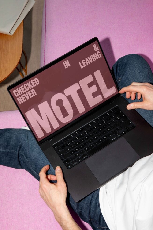 Laptop showing bold MOTE font design Never Checked In Leaving Motel on pink sofa Digital asset Graphic Template for Designers SEO keywords Mockup Modern