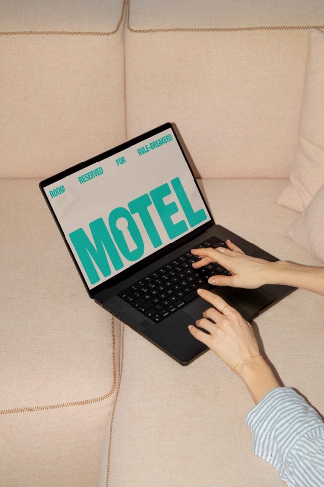 Designer working on laptop with bold font design for MOTEL project on screen. Ideal for graphic design templates, typography mockups, digital assets.