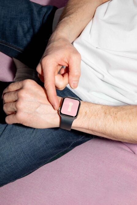 Smartwatch on wrist with blank pink screen and keyhole design. Use for smartwatch mockups, design templates, digital assets for graphic designers.