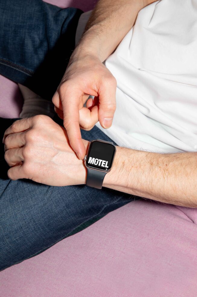 Person wearing a smartwatch displaying the word Motel in bold font. Ideal for digital assets, graphic design, mockups, app templates, modern UI.
