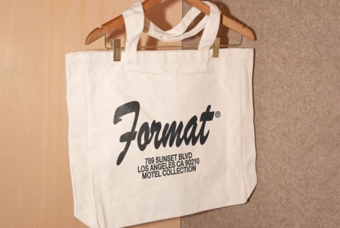 Canvas tote bag with custom typography design featuring Format branding hanging on a wooden hanger perfect for graphic and template design projects.
