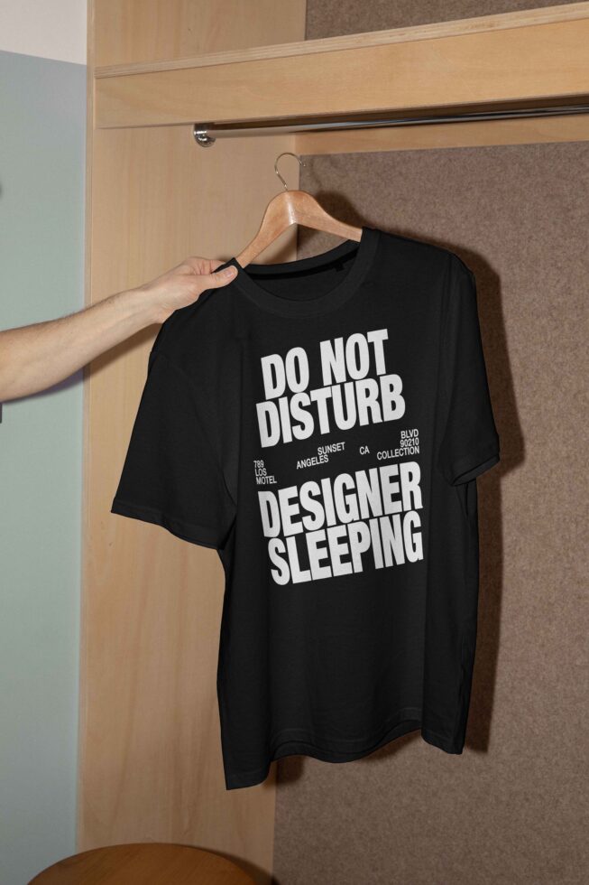 Black T-shirt mockup on hanger with bold white text Do Not Disturb Designer Sleeping perfect for graphic designers fashion apparel template