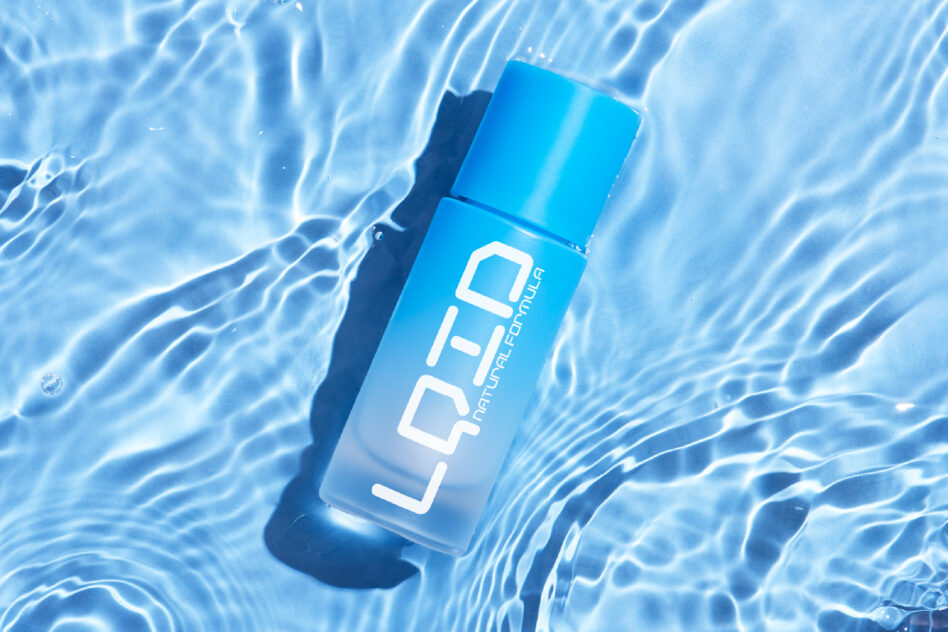 Blue cosmetic bottle floating in crystal clear pool water with rippling surface