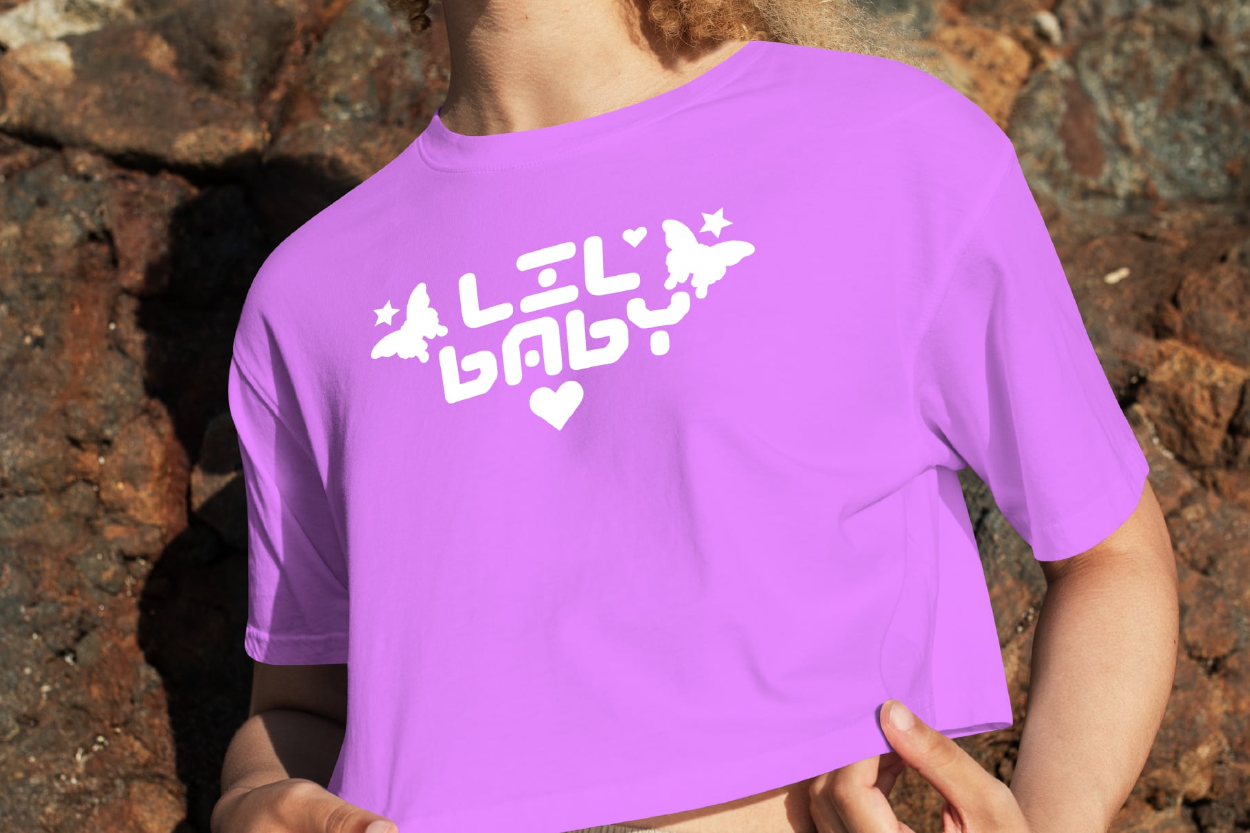 Magenta crewneck tee with white graphic design featuring celestial elements, worn outdoors