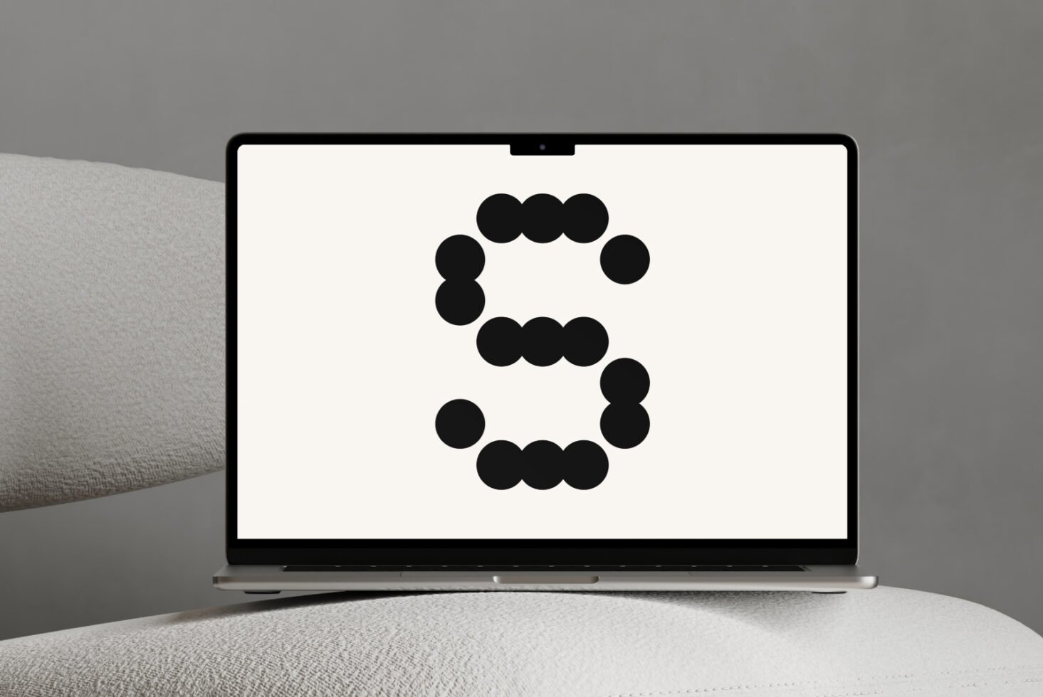 Laptop mockup showing a bold S made of black dots on white screen. Perfect for designers seeking innovative typography presentation or logo concepts.