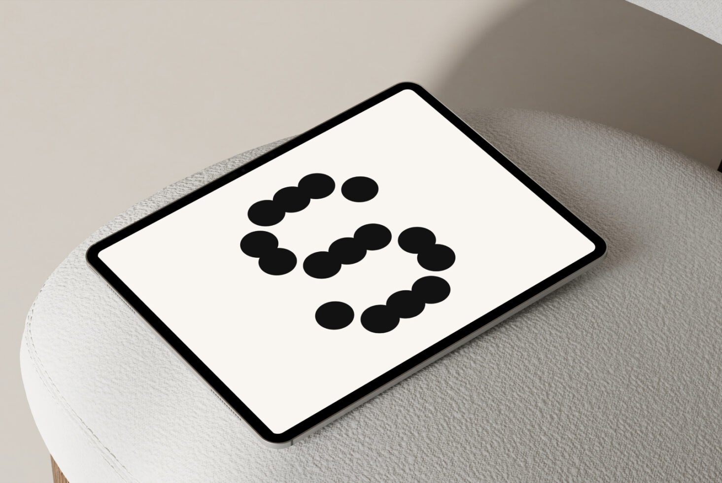 Tablet with minimalist design template displaying a dotted letter S on a light background placed on a modern textured surface suitable for digital assets.