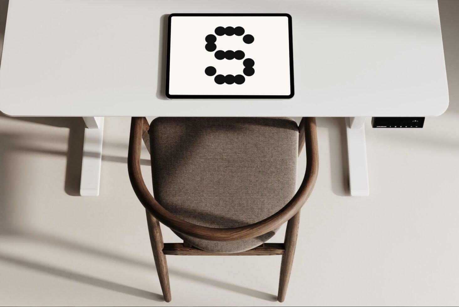 Stylish workspace mockup featuring tablet with letter S in a dot font on a white desk background. Ideal for branding and graphic design projects.