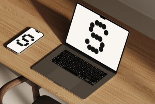 Laptop and smartphone wooden desk mockup with abstract design on screens. Ideal for showcasing digital templates and graphics for designers.