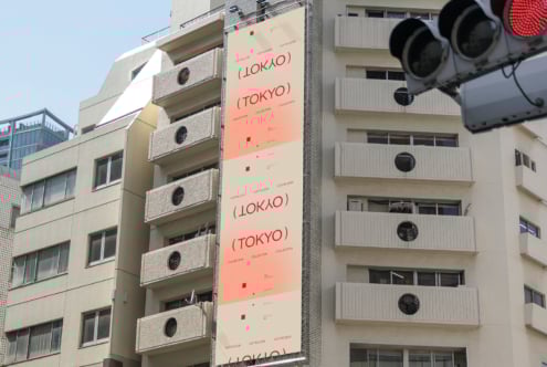 Urban building facade with vertical signboard featuring red text LOKYO TOKYO, useful for mockups, graphic design, branding templates, urban aesthetics.