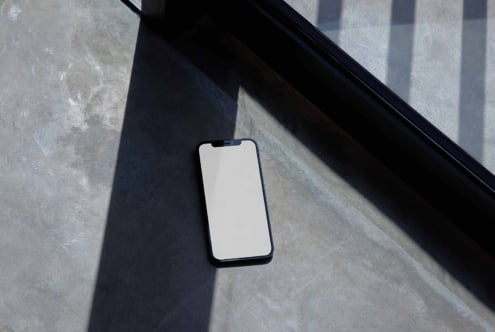 Smartphone screen mockup on concrete floor with window shadows minimalist design ideal for UI UX showcase digital assets designers template mockups.