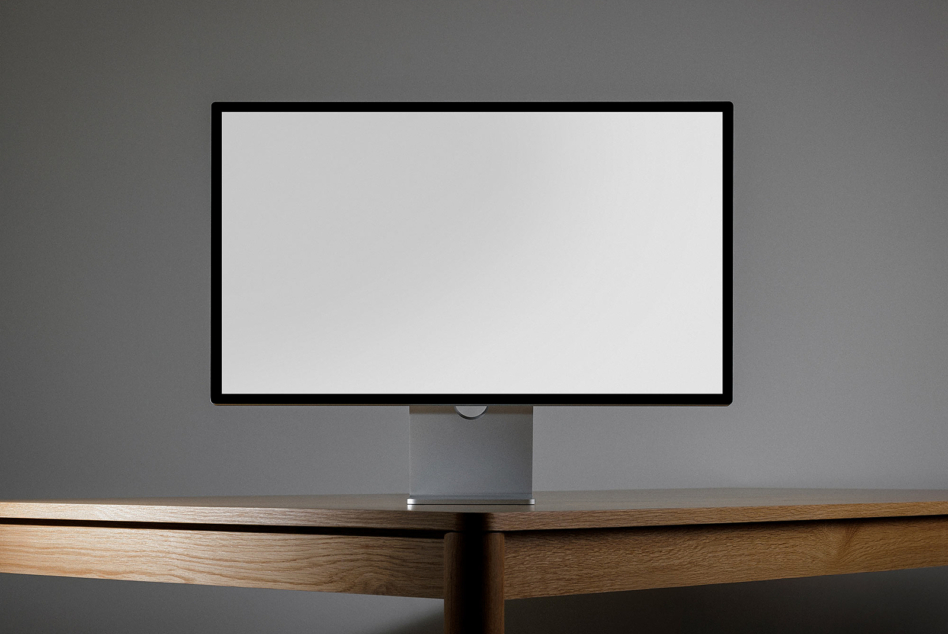 Horizontal desktop monitor on wooden desk with blank white screen