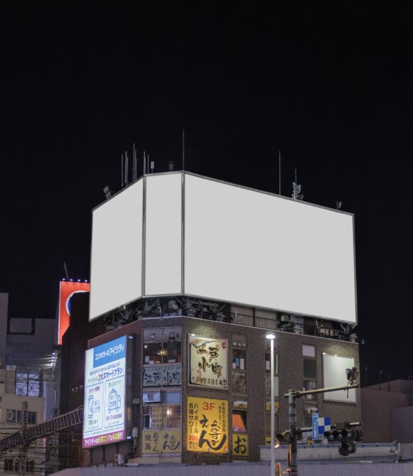 Nighttime rooftop billboard with blank white panels above Tokyo street-level shops
