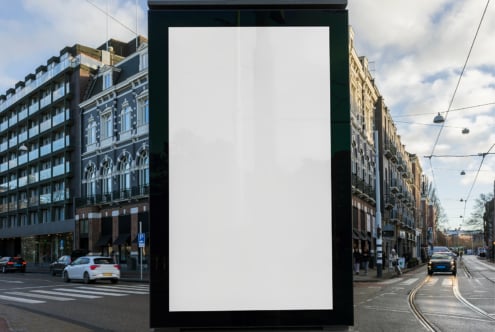 Urban street scene with a large blank billboard for mockup template display. Perfect for showcasing outdoor advertising designs in a bustling city setting.