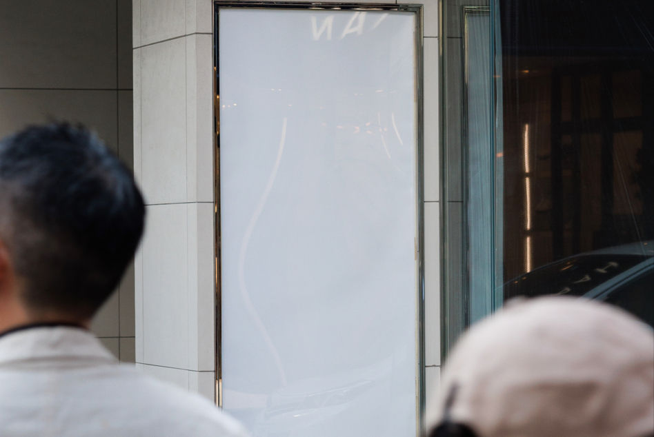 Clean storefront window display mockup with empty light-colored poster space