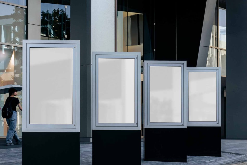 Four outdoor digital billboards with white frames descending in size, all displaying blank white screens