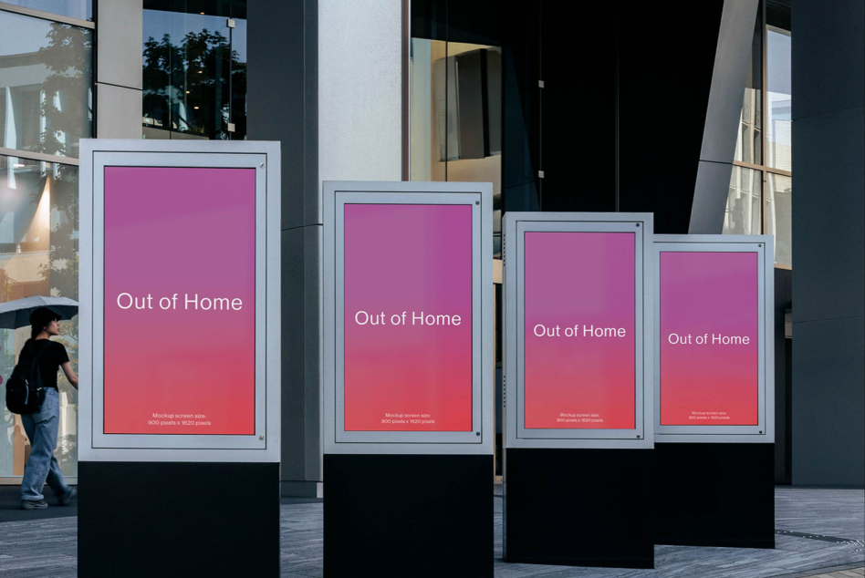Four outdoor digital billboards with white frames descending in size showing pink gradient display with Out of Home text