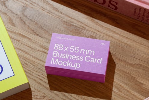 Stack of purple business cards on wooden surface designed as an 88 x 55 mm business card mockup ideal for graphic design and branding projects.