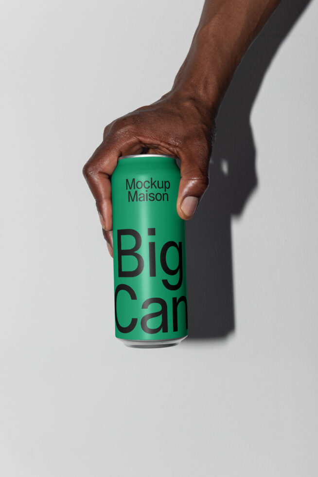Hand holding a green soda can mockup with Big Can text against a white background; perfect for branding designers and product presentation.