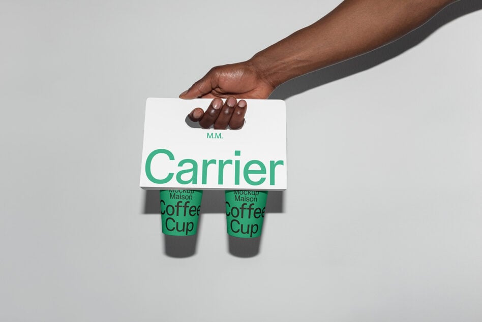 Hand holding a coffee cup carrier with green text branding. Ideal mockup for designers focusing on packaging, typography, and branding projects.