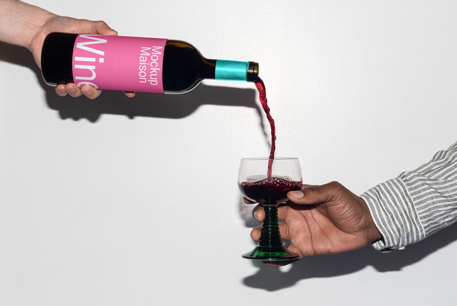 Wine bottle pouring red wine into glass held by hand mockup. Ideal for designers needing high-quality product visualizations. Suitable for mockup needs.