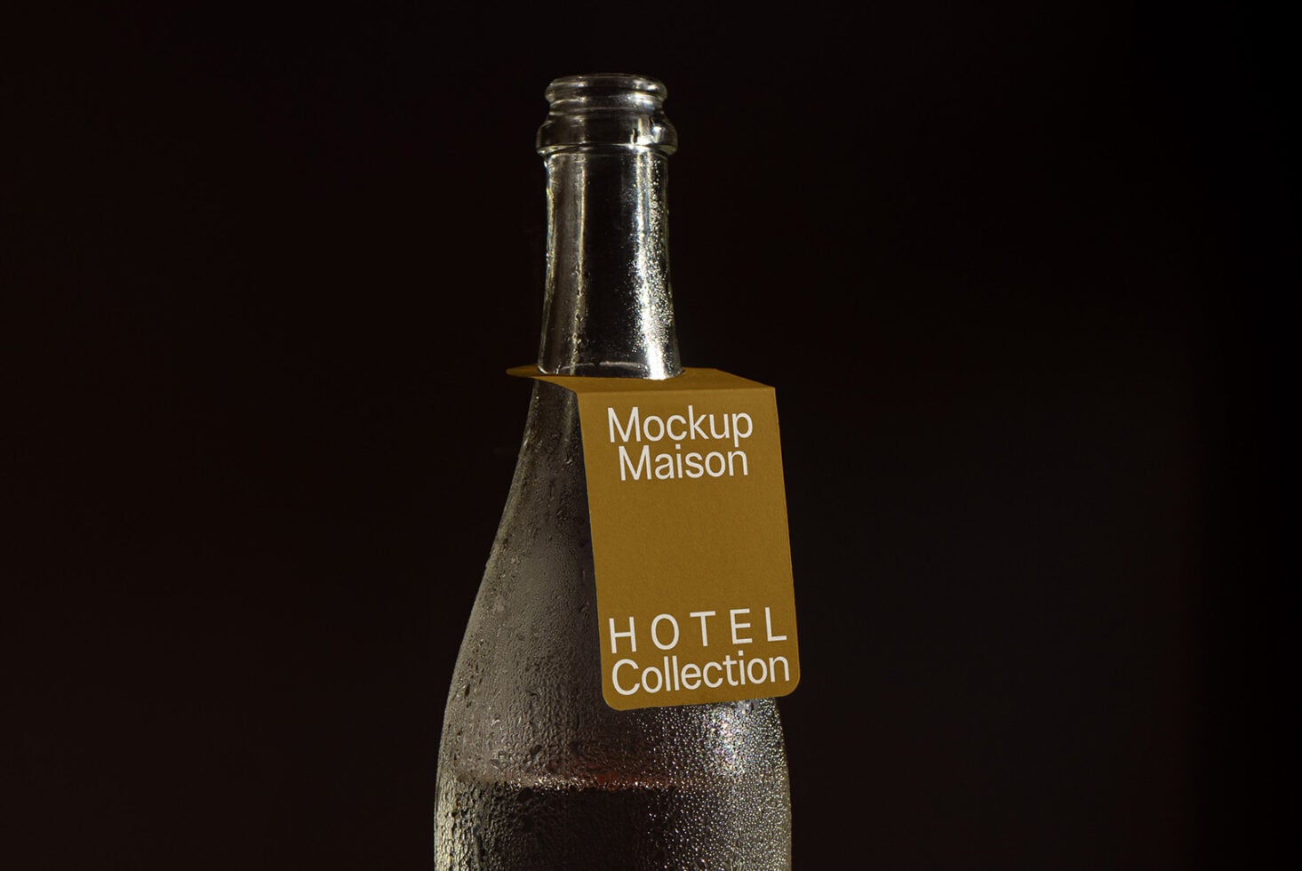 Chilled glass bottle wearing mustard colored label on black background