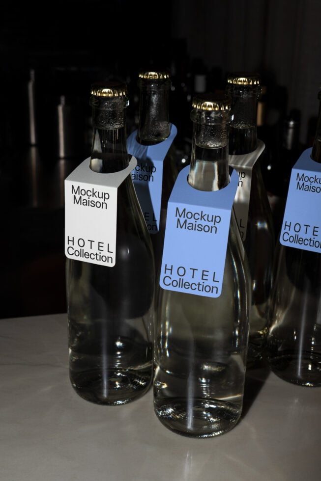 Multiple labeled bottles with gold caps arranged in dark lighting setup
