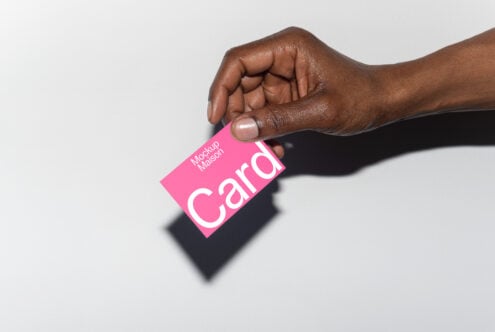 Pink business card mockup held by hand on light background suitable for designers and branding projects keywords business card mockup design asset