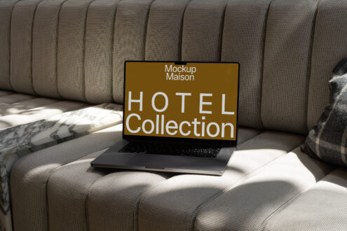Laptop displaying Hotel Collection mockup on a cushioned sofa with marble table. Keywords: Laptop Mockup Hotel Collection Template Design.