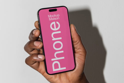 Modern smartphone mockup in a hand with a pink screen featuring text. Ideal for designers seeking device templates for digital presentations.