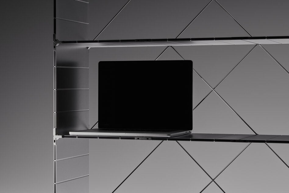 Dark laptop mockup displayed on geometric shelving system from side angle