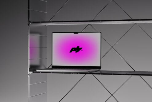 Laptop on minimalist shelf with modern geometric background featuring digital graphic mockup in vibrant pink ideal for design templates and presentations.