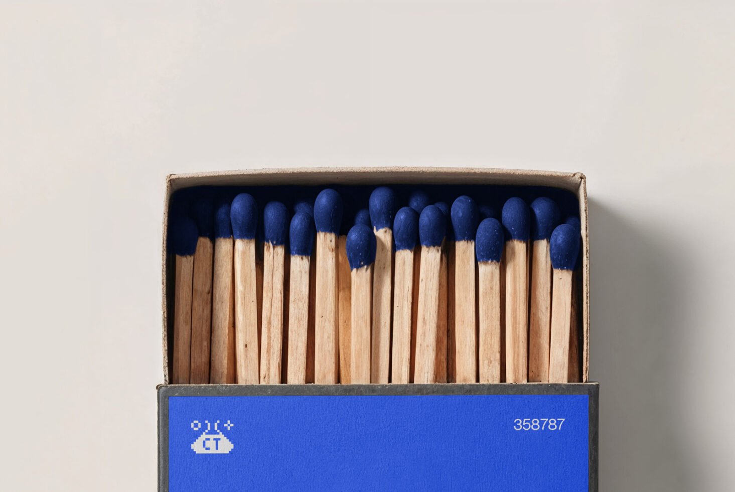 Box of matches with blue heads in a cardboard box. Perfect for mockups or designs needing matchstick imagery. Ideal for creative projects.
